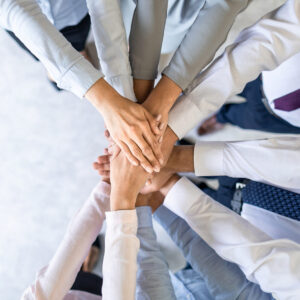 Close up top view of young business people putting their hands together. Stack of hands. Unity and teamwork concept.