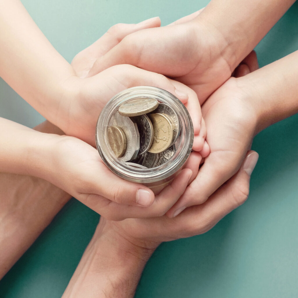 Family hands cupped around a jar full of coins, family budget concept