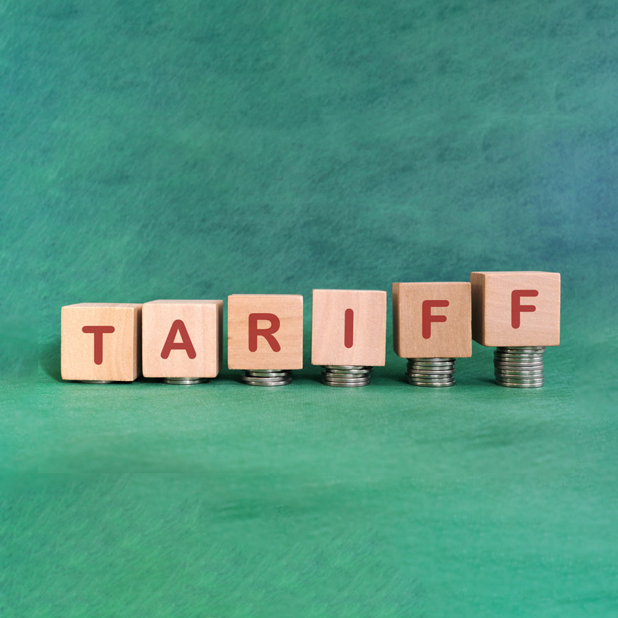 Increase tariff tax concept. Word in wooden blocks with increasing stack of coins.